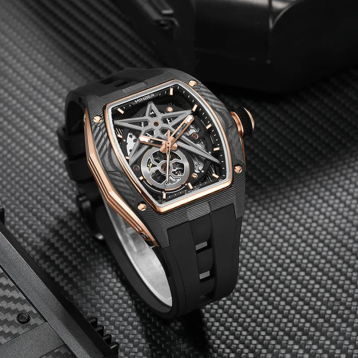 Luxury skeleton watch with carbon fiber case, rose gold accents, and sporty rubber strap on textured surface