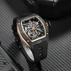 Luxury skeleton watch with carbon fiber case, rose gold accents, and sporty rubber strap on textured surface