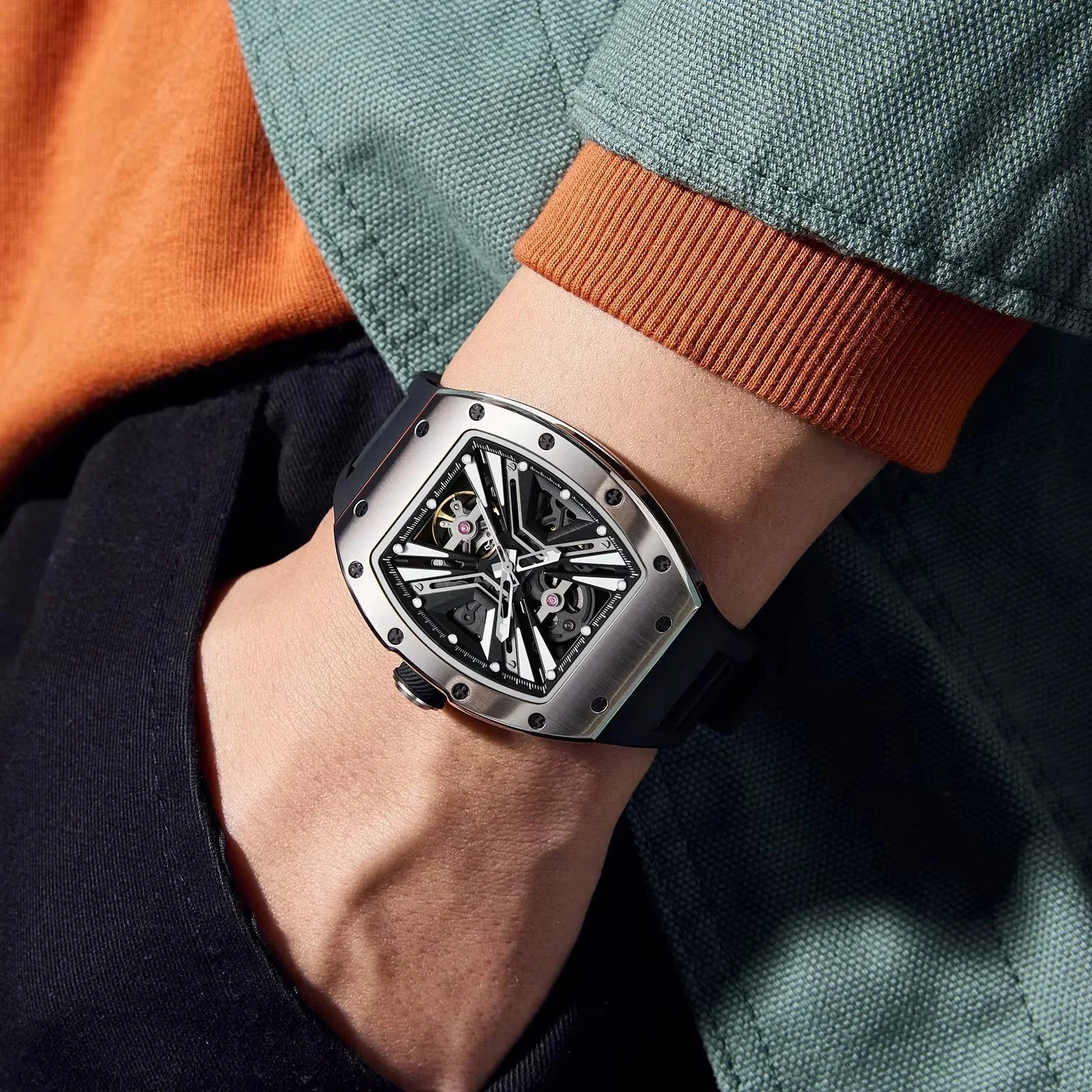 Luxury motorsport-inspired tonneau watch with skeleton dial and bold black strap on wrist