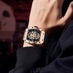 Luxury motorsport-inspired skeleton watch with rose gold case and black strap on wrist