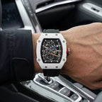 Luxury skeleton watch with white case, black strap, red crown, worn in car — motorsport-inspired design