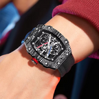 Carbon fiber skeleton watch with bold motorsport design, red crown, and sport-luxury style on wrist