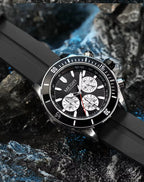 Motorsport-inspired black chronograph watch with bold dial and sporty rubber strap on rocks
