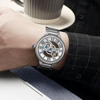 Luxury sport-inspired skeleton watch with Roman numerals and stainless steel bracelet on wrist