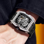 Luxury skeleton dial watch with square case, black rubber strap, motorsport-inspired design on wrist