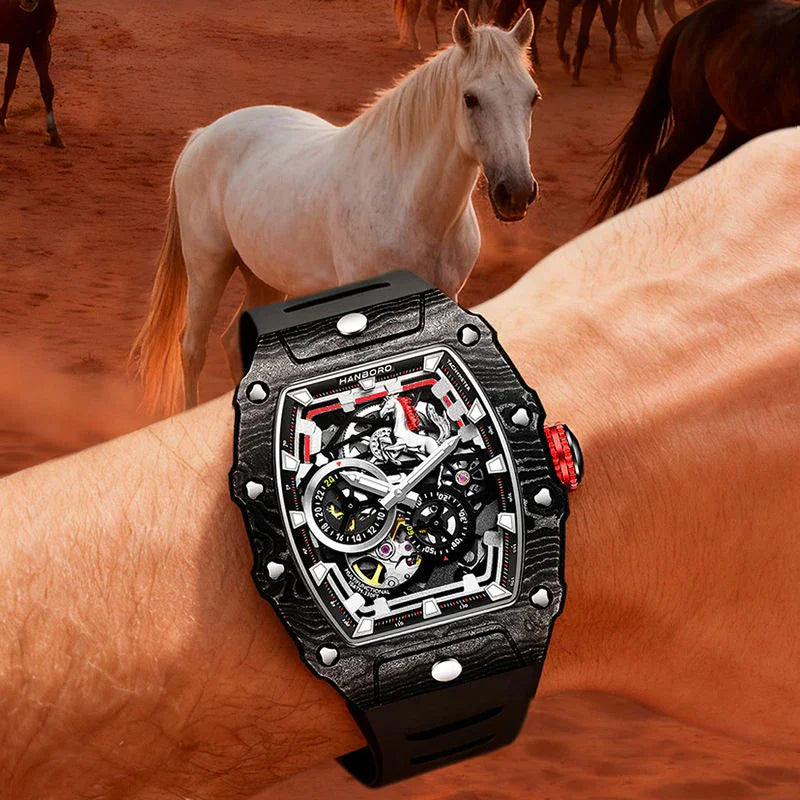 Luxury motorsport-inspired skeleton watch with black carbon fiber case on wrist, horses in background