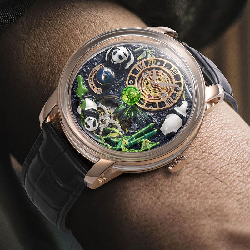 Luxury sport-inspired watch with panda and bamboo dial, gold case, and black leather strap on wrist