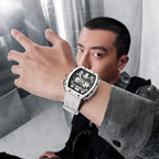 Man wearing a modern racing-inspired white watch with a skeleton dial and bold design.