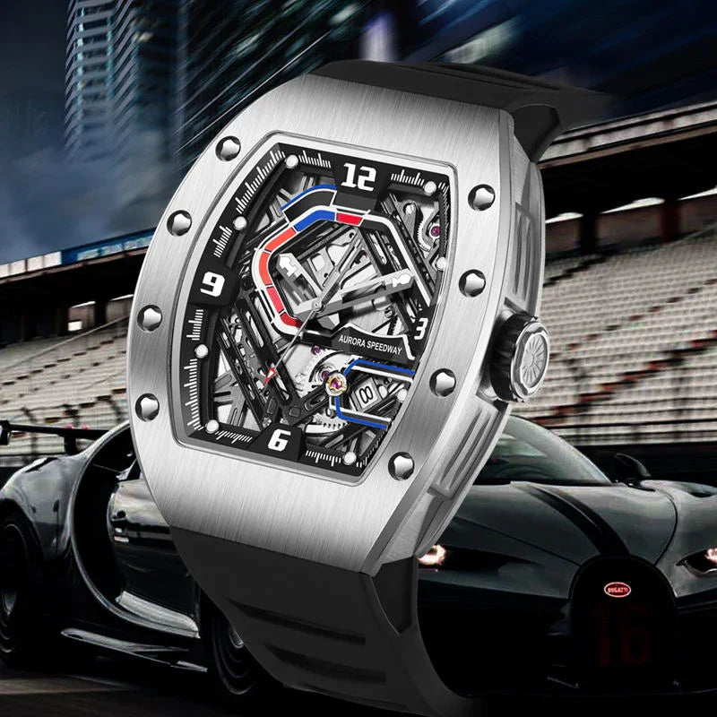 Luxury motorsport-inspired skeleton watch with brushed metal case and bold design in front of a sports car at a racetrack.