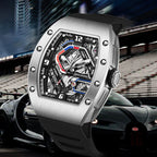 Luxury motorsport-inspired skeleton watch with brushed metal case and bold design in front of a sports car at a racetrack.