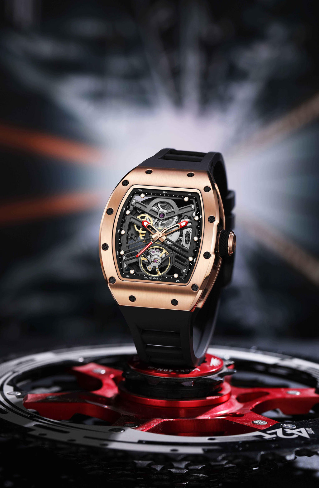 Luxury motorsport-inspired skeleton watch with rose gold case and black rubber strap on gear