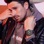 Man wearing sporty luxury homage watch with bold case, black leather jacket, and gray hoodie