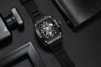 Skeleton dial sport-luxury watch with black rubber strap and brushed case, motorsport-inspired design
