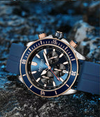 Blue sport chronograph watch with bold dial and rose gold accents on textured rock background
